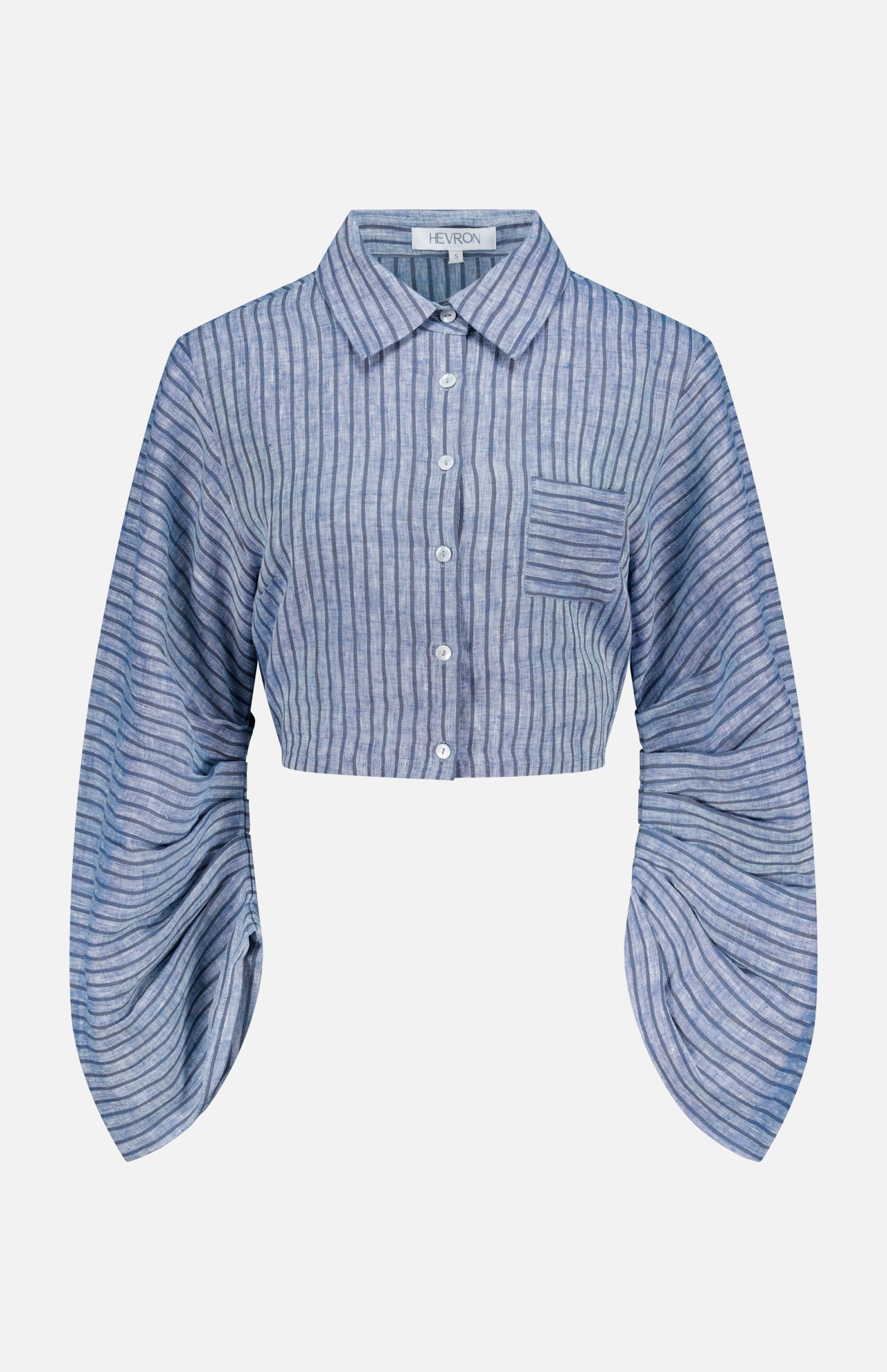 The Raquel Pleated Sleeves Top by HEVRON features blue stripes, a cropped button-up design, collar, chest pocket, and exaggerated pleated sleeves for a modern touch.