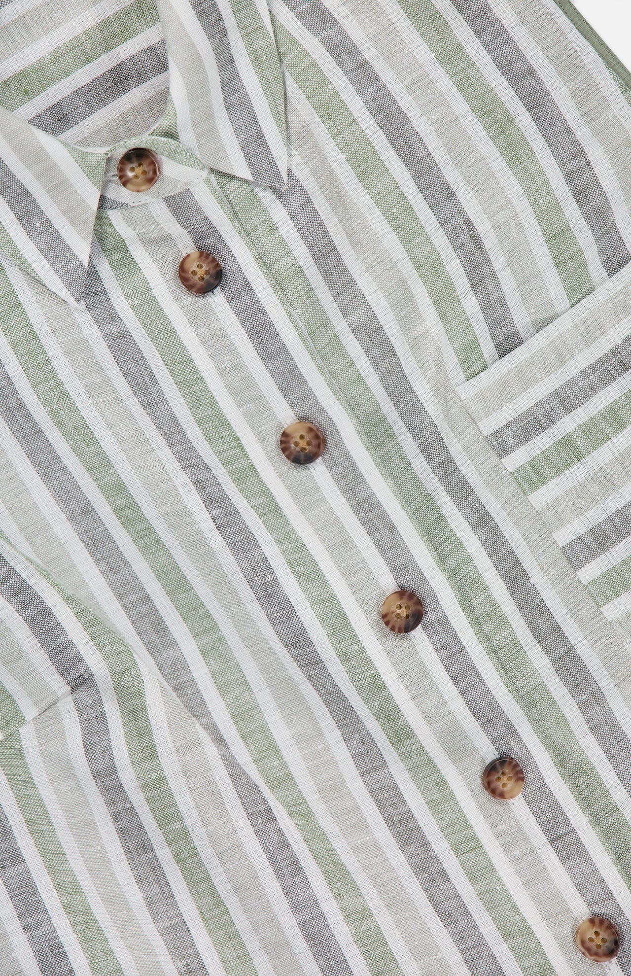Close-up of the HEVRON Katja Striped Linen Top, featuring vertical green, white, and gray stripes, brown tortoiseshell buttons, a collar, and chest pocket. Light, breathable fabric makes it perfect for summer.