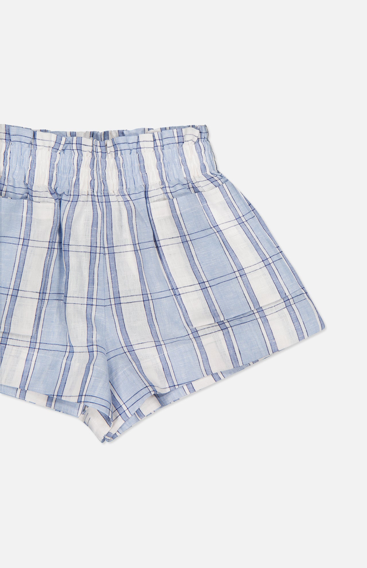 The HEVRON Mira Plaid Linen Short features a light blue and white plaid pattern with an elastic waistband, shown on a plain white background. Designed for a relaxed fit, these shorts offer casual comfort and effortless style.