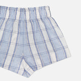 The HEVRON Mira Plaid Linen Short, shown in light blue and white with an elastic waistband and soft linen fabric, is displayed against a plain white background. Only half of the shorts are visible in the image.