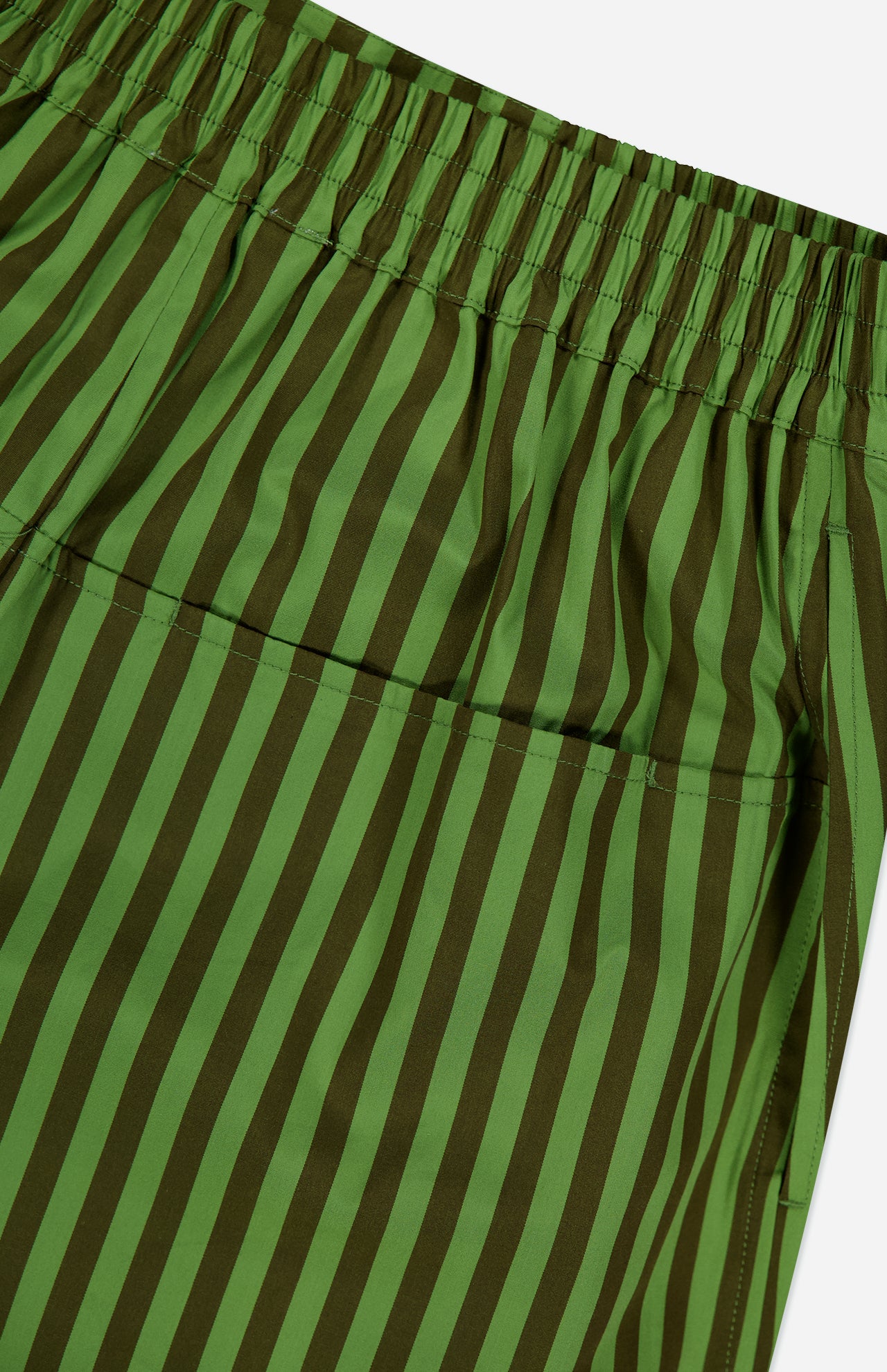 Close-up of HEVRON Remi Stripe Shorts featuring green and dark green vertical stripes, an elastic waistband, and a back pocket.