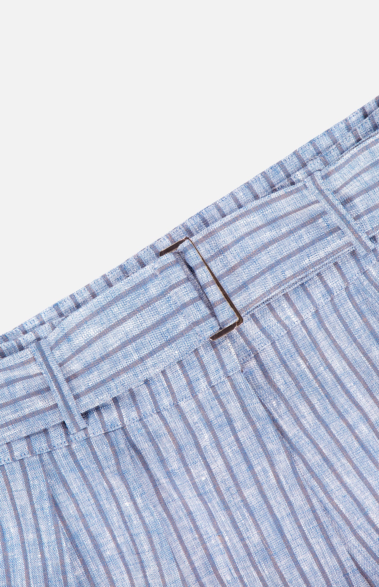 Close-up of HEVRON's Zinna Stripe Linen Short, showcasing light blue and white vertical stripes, a self-tie fabric belt at the waistband, and a rectangular metal buckle.
