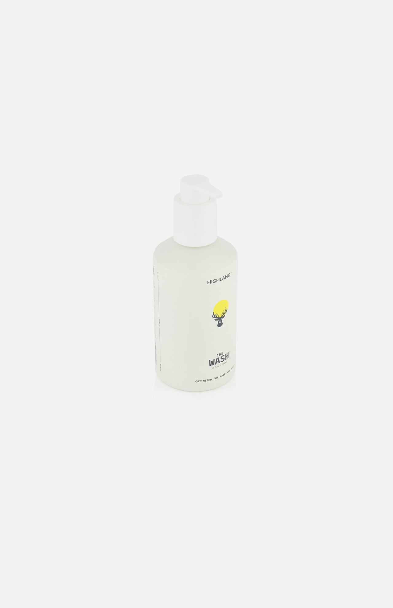 A white pump bottle of HIGHLAND STYLE CO. The Wash Hair Care features minimalist labeling with a small yellow illustration and the word WASH on the front, set against a plain white background.