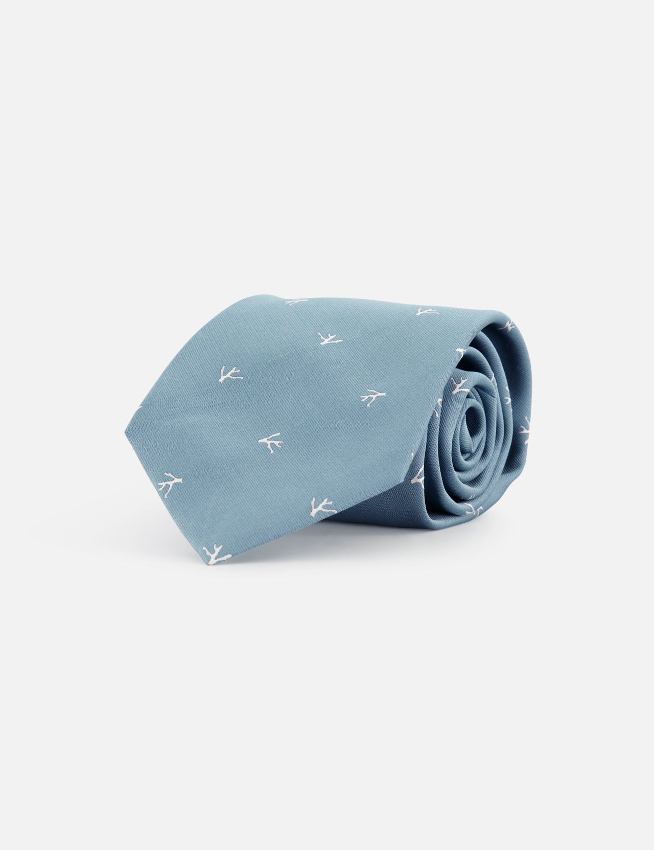 The ISAIA Fantasia Cravatte Coral Print Silk Tie features a light blue hue with subtle white arrow patterns, elegantly rolled and set against a plain white background.