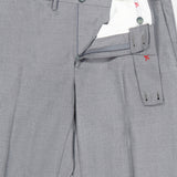 A pair of ISAIA 150′s Timeless Casalnuovo Trouser Pants in light gray wool, featuring a tailored fit with an extended tab waistband, belt loops, and visible interior white lining accented by red stitching. Made in Italy, the trousers are partially unzipped and neatly folded.