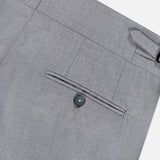 Close-up of the ISAIA 150′s Timeless Casalnuovo Trouser Pant in light grey, featuring the back pocket with button closure, a belt loop, and part of the waistband. The smooth, fine-textured fabric highlights the refined quality of these Italian-made wool trousers.