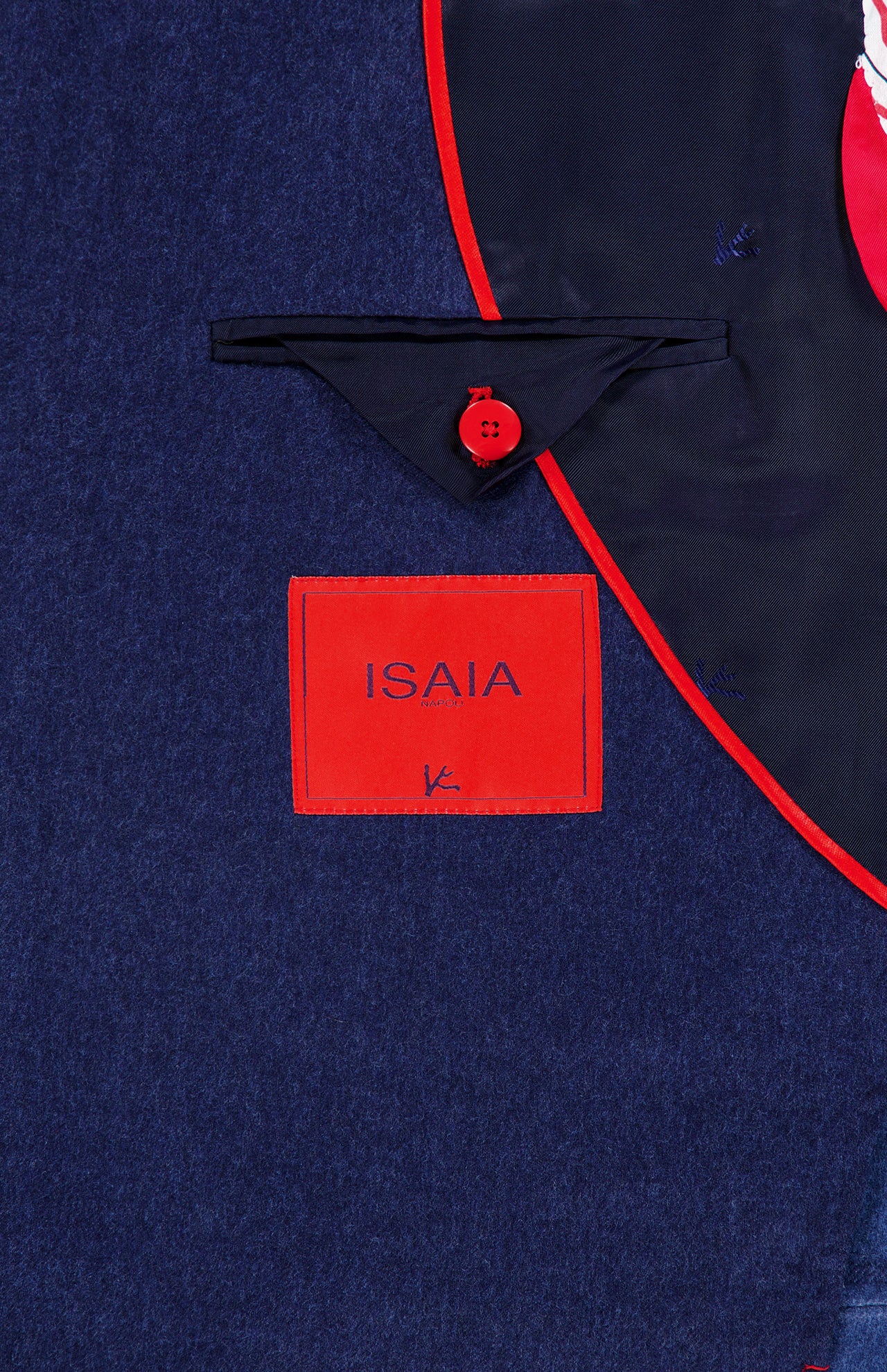 Close-up of the Australian Merinos Double Face Sportcoat by ISAIA, featuring a navy wool-blend lining with a red-bordered pocket, red button, and a red label reading ISAIA in blue letters. This elegant sportcoat is expertly made in Italy.