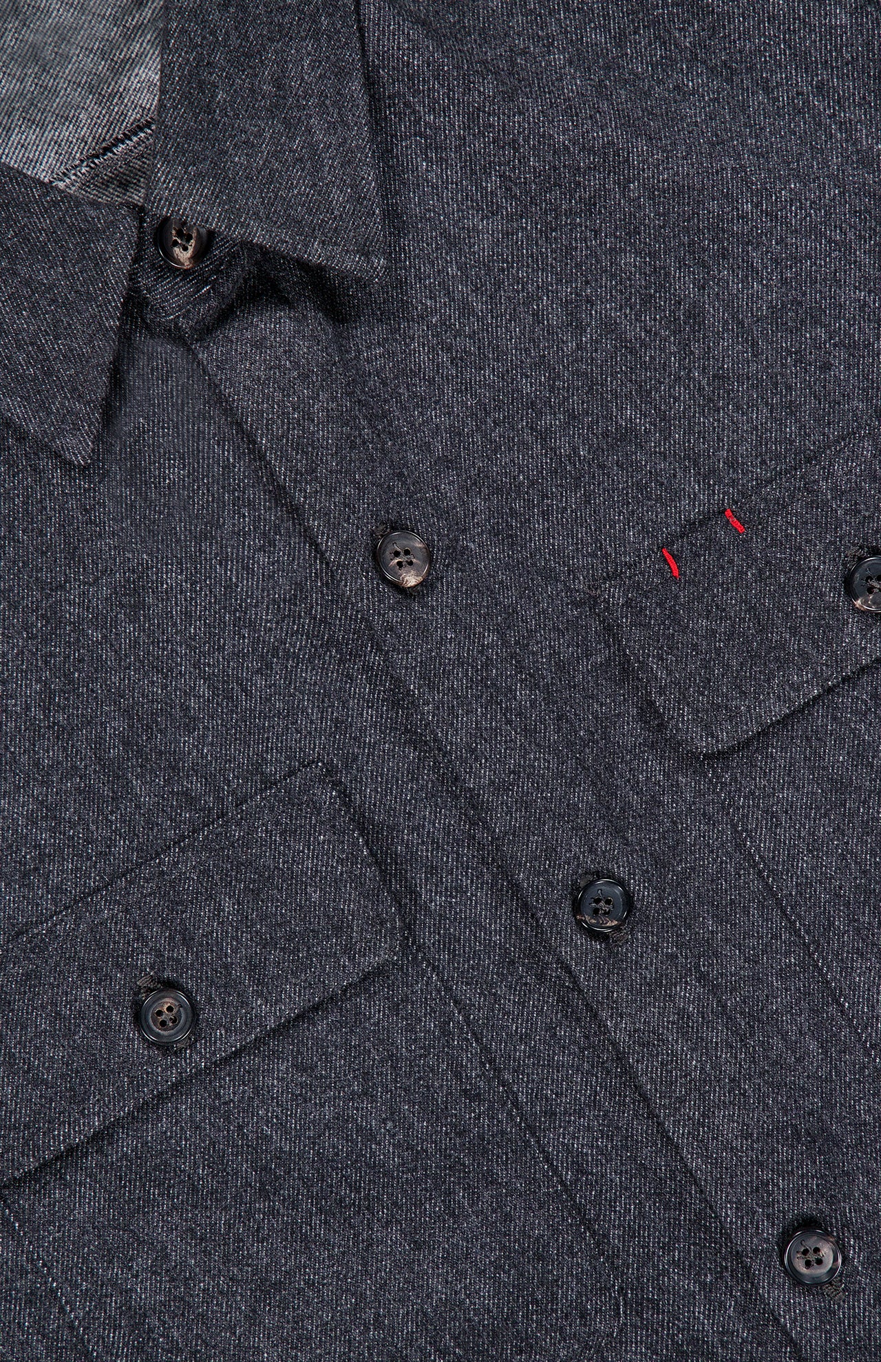 Close-up of the Cashmere Denim Effect Overshirt by ISAIA—a luxury men’s layering piece crafted in Italy, featuring a dark gray hue, button-up design, dual chest pockets, and subtle red stitching above the left pocket flap.