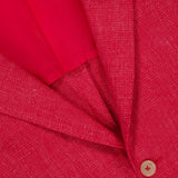 Close-up of the ISAIA Cashsilk & Linen Sportcoat in luxury red, made in Italy, showcasing textured fabric, a visible lapel, button, and part of the red inner lining.