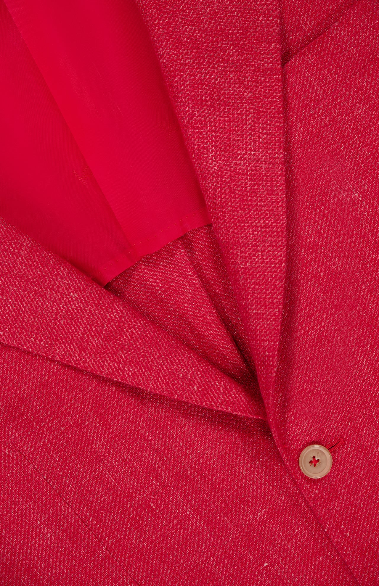Close-up of the ISAIA Cashsilk & Linen Sportcoat in luxury red, made in Italy, showcasing textured fabric, a visible lapel, button, and part of the red inner lining.
