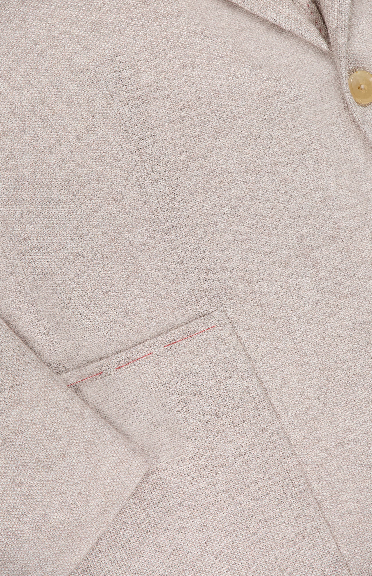 Close-up of ISAIA's Cotton Linen Jersey Sportcoat, made in Italy, showcasing its beige textured fabric, subtle red pocket stitching, and a single tan button near the lapel.