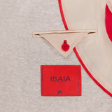 Close-up of the inside of an ISAIA Cotton Linen Jersey Sportcoat in beige with red trim, featuring a red brand label, tan pocket with triangular flap, and red button. Expertly crafted in Italy from a fine cotton-linen blend.