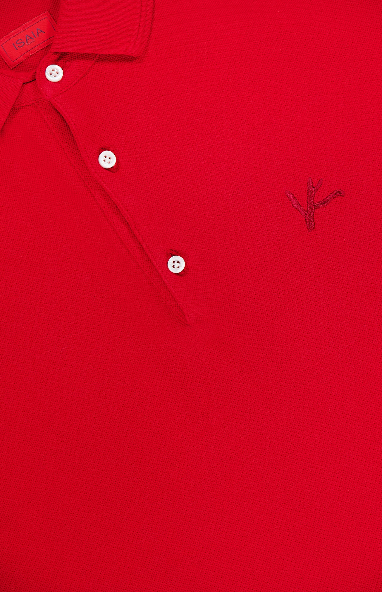 Close-up of the ISAIA Cotton Piquet Jersey Short Sleeve Polo Shirt in red, featuring three white buttons, a dark stitched branch logo on the right, and a red ISAIA label near the collar.