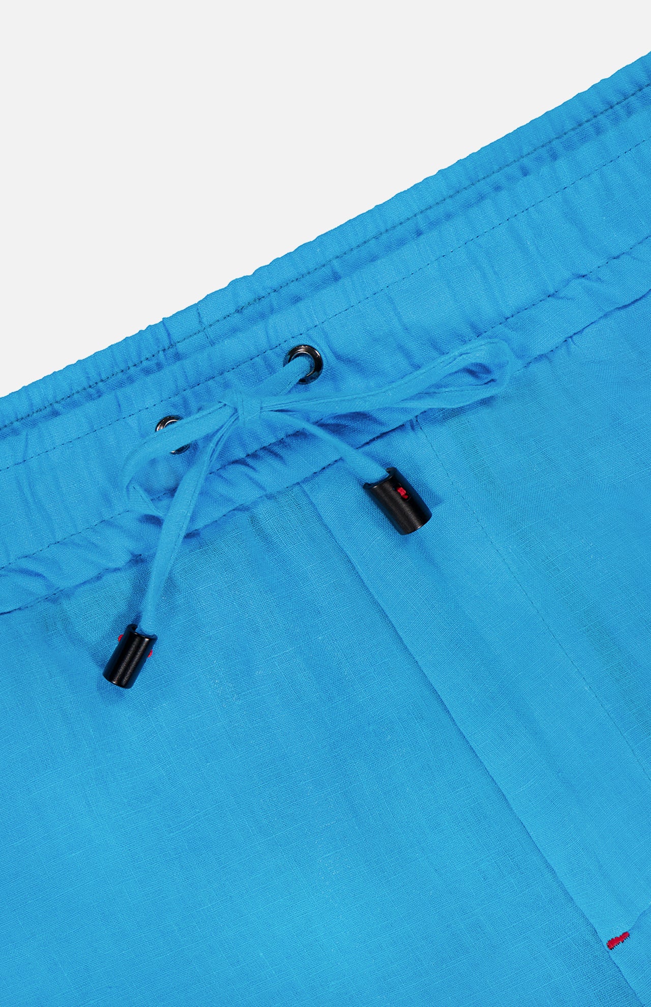 Close-up of the waistband on ISAIA's Drawstring Wide Leg Linen Corallo Trouser Pant, featuring bright blue linen, drawstring ties with black plastic tips, metal eyelets, a visible seam, and part of a pocket—perfect for vacation style.