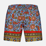 The ISAIA Drawstring Printed Swim Trunk features a blue base with vivid red, yellow, and green floral and paisley prints, plus ornate geometric borders—ideal for stylish beachwear.
