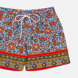 ISAIA Drawstring Printed Swim Trunk: men's swimwear with a vibrant floral and paisley print on light blue, drawstring waistband, and red, yellow, and blue decorative borders—ideal for stylish beachwear.