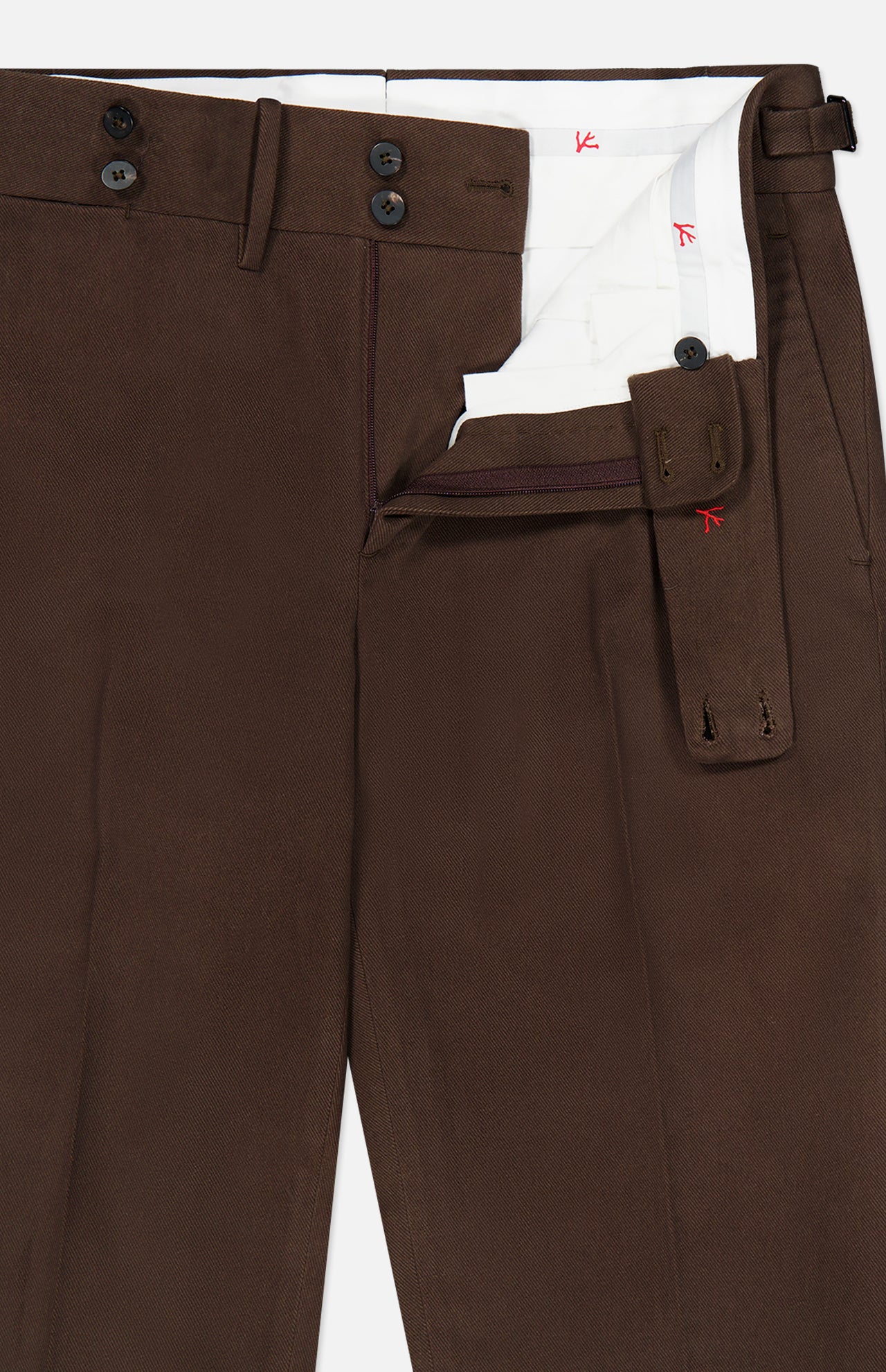The Dynamic Comfort Casalnuovo Trouser Pant by ISAIA features a dark brown hue with a partially open waistband that reveals white interior lining and button closures. Made in Italy in the classic Neapolitan trousers style, these pants also include a side adjuster strap with buttonholes for a perfect fit.