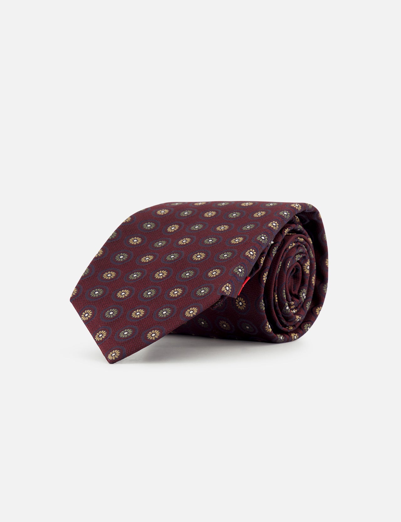 A rolled-up ISAIA Floral Pattern Tie in burgundy, featuring a repeating small circular pattern in yellow and blue, displayed on a plain white background.