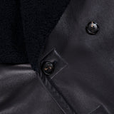 Close-up of an Isaia Leather Sherpa Double Breasted Peacoat, featuring a double-breasted black leather design with a dark sherpa collar and three visible buttons.