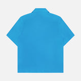 The ISAIA Linen Coral Embroidery Shirt features a boxy fit, short sleeves, and a classic collar in bright blue linen. Shown from the back on a plain white background, it’s the perfect vacation style piece.