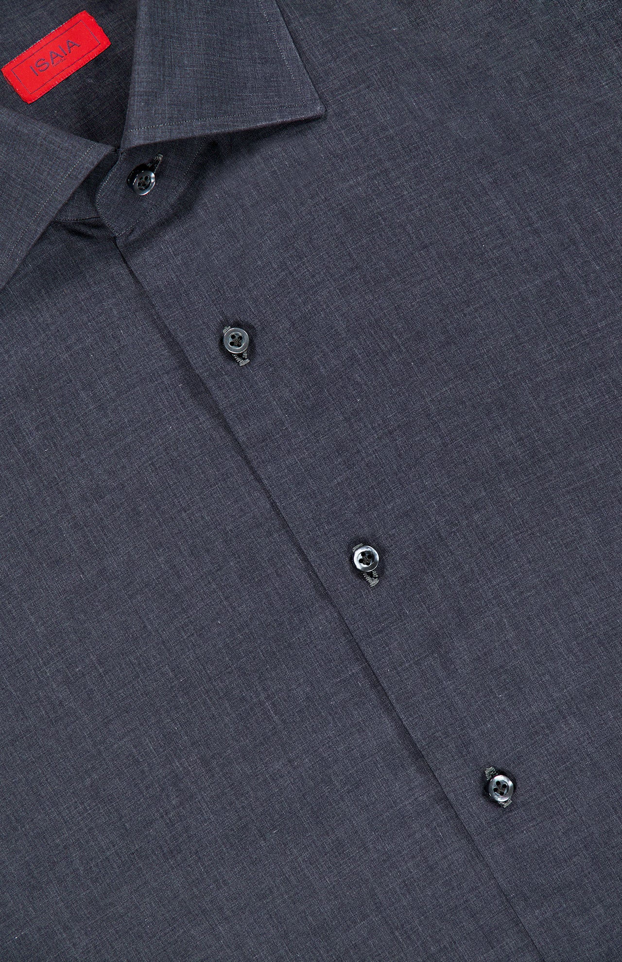 A close-up of the ISAIA Mussola Cotton Dress Shirt in dark grey showcases its collared design and visible black buttons. Made from easy-care cotton, this shirt is accented with a small red tag featuring text near the collar.