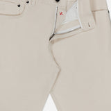 A pair of Napoli Stretch Denim Jeans by ISAIA in light beige cotton denim, featuring a partially open front zipper and button that reveals the white inner lining and distinctive red stitching detail near the top button.