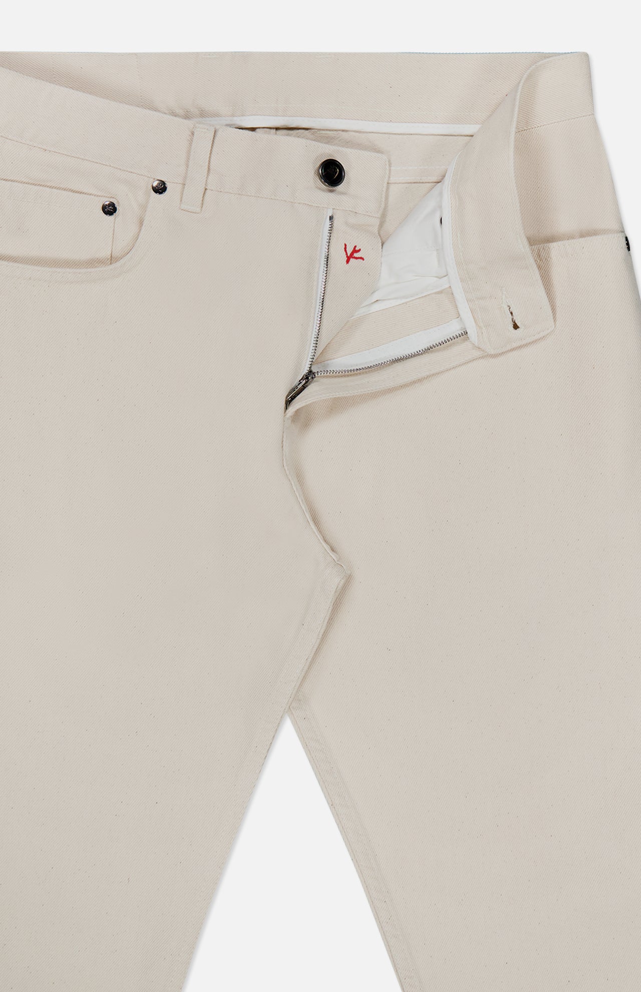 A pair of Napoli Stretch Denim Jeans by ISAIA in light beige cotton denim, featuring a partially open front zipper and button that reveals the white inner lining and distinctive red stitching detail near the top button.