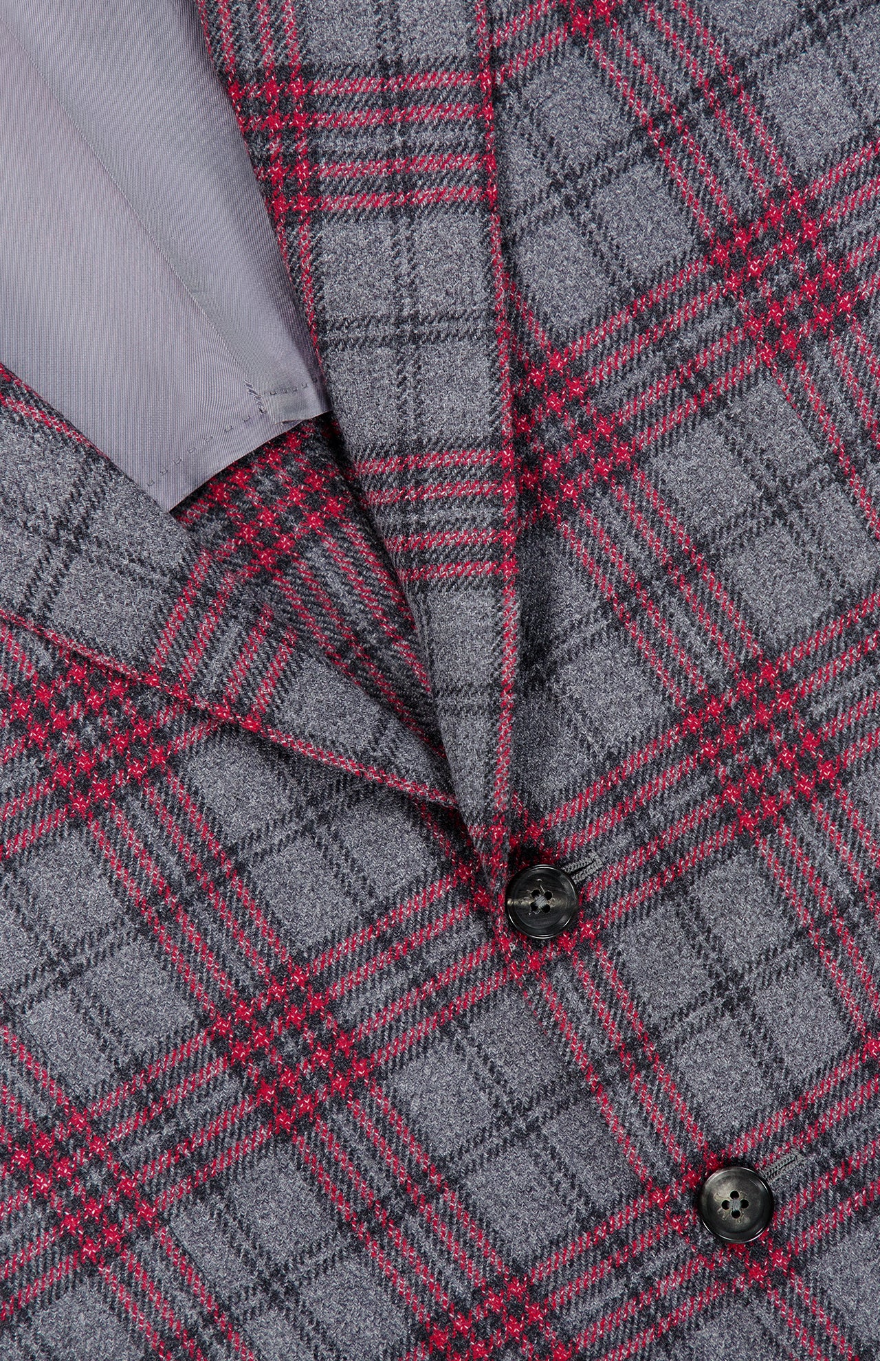 Close-up of an Over Checkered Cashwool Sportcoat by ISAIA in grey and maroon plaid, highlighting two black buttons and a glimpse of the light grey inner lining. This Italian-made wool cashmere jacket features sophisticated red and black overcheck stripes for a refined touch.