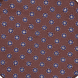 The Paisley Pocket Square by ISAIA is crafted in Italy from brown silk and features a repeating pattern of small blue and white floral motifs arranged diagonally on a white background.
