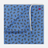 The ISAIA Paisley Print Pocket Square features blue linen with a dark paisley pattern, a white border, and a folded corner that shows the reverse and a small red embroidered detail—ideal for pocket square enthusiasts.