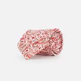 The ISAIA Paisley Print Silk Tie, showcasing a red, beige, and white paisley design, is rolled up and displayed on a plain white background.
