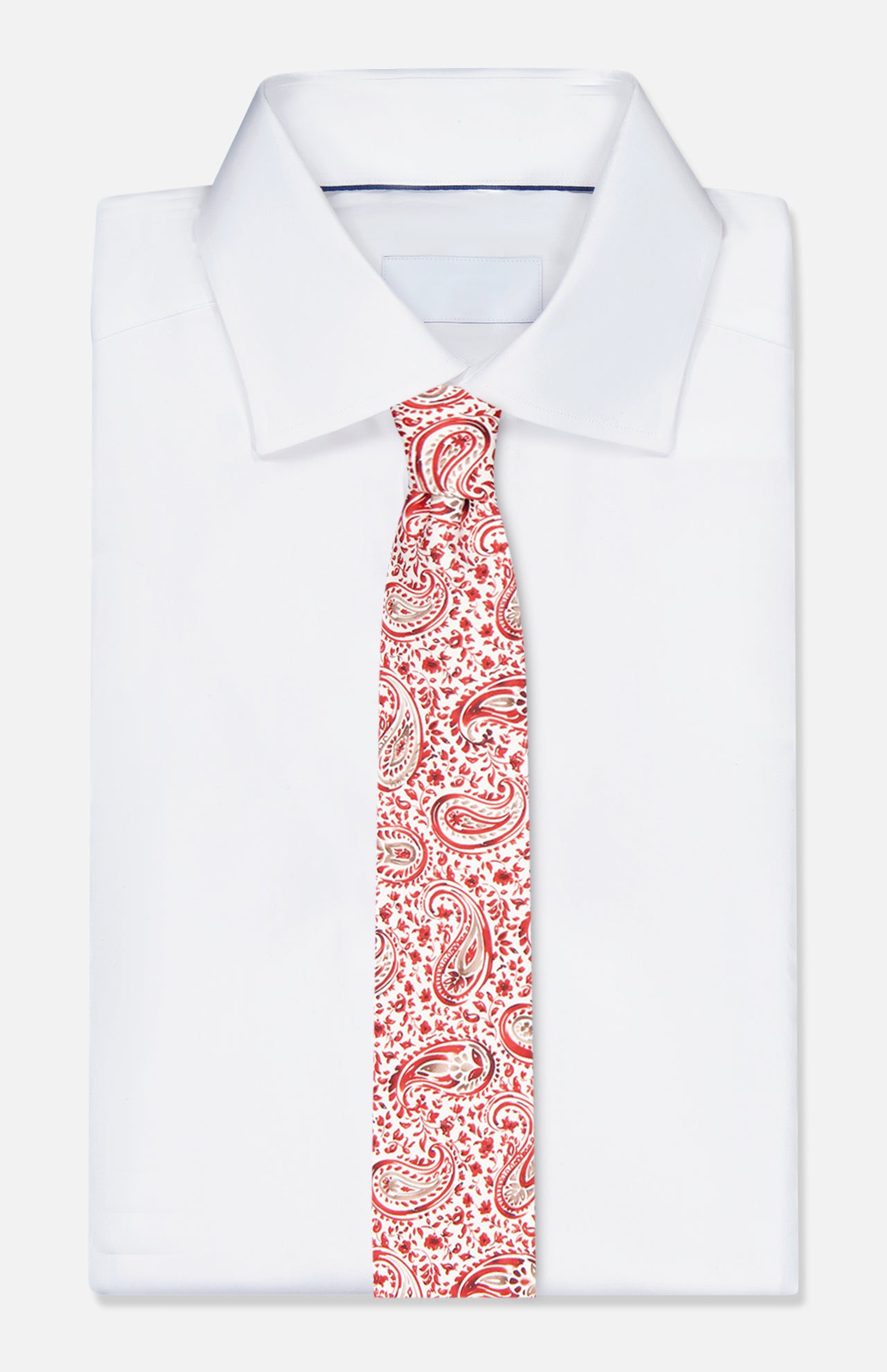 A Paisley Print Silk Tie by ISAIA is laid on top of a neatly folded white dress shirt, displayed against a simple light background.