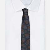 An ISAIA Paisley Neck Tie in dark green silk is elegantly draped over a folded white dress shirt, presented against a simple light background.