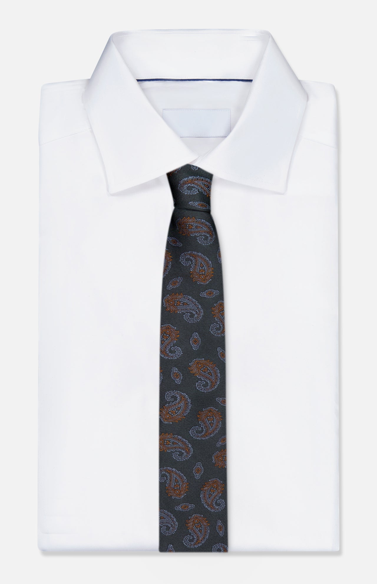 An ISAIA Paisley Neck Tie in dark green silk is elegantly draped over a folded white dress shirt, presented against a simple light background.
