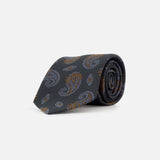 ISAIA Paisley Neck Tie in dark gray silk, featuring a blue and orange paisley print, shown rolled up against a plain white background.