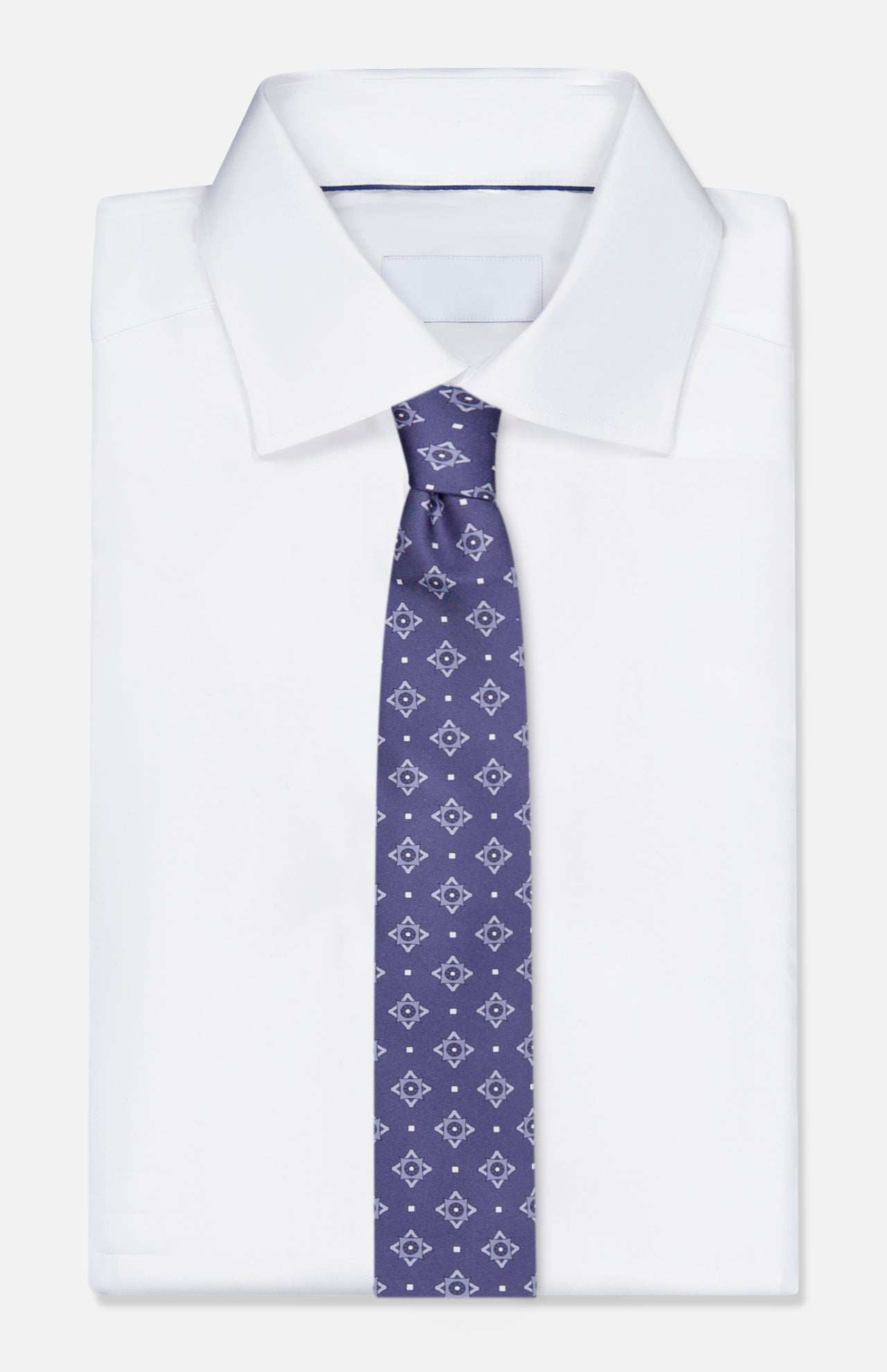 A neatly folded white dress shirt with a pointed collar is paired with the ISAIA Pattern Neck Tie, a luxurious Italian silk necktie in purple adorned with a small geometric diamond pattern, displayed against a plain white background.
