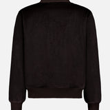 Back view of the ISAIA Peruvian Alpaca Varsity Bomber Jacket in plain black, featuring ribbed cuffs, hem, and collar. The soft, plush fabric highlights its classic varsity bomber silhouette with no visible logos or designs.