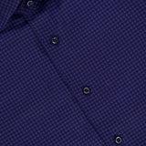 Close-up of the ISAIA Print Oxford Dress Shirt, featuring a blue and black micro houndstooth pattern with black buttons. The collar and a red ISAIA label are partially visible in the upper left corner, showcasing refined detailing characteristic of Italian dress shirts.