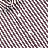 Close-up of the Rigato Popeline Dress Shirt by ISAIA, an Italian design featuring vertical black and white stripes. Crafted from easy-care cotton, the shirt showcases white buttons and a pointed collar, with part of a signature red label visible at the top left.