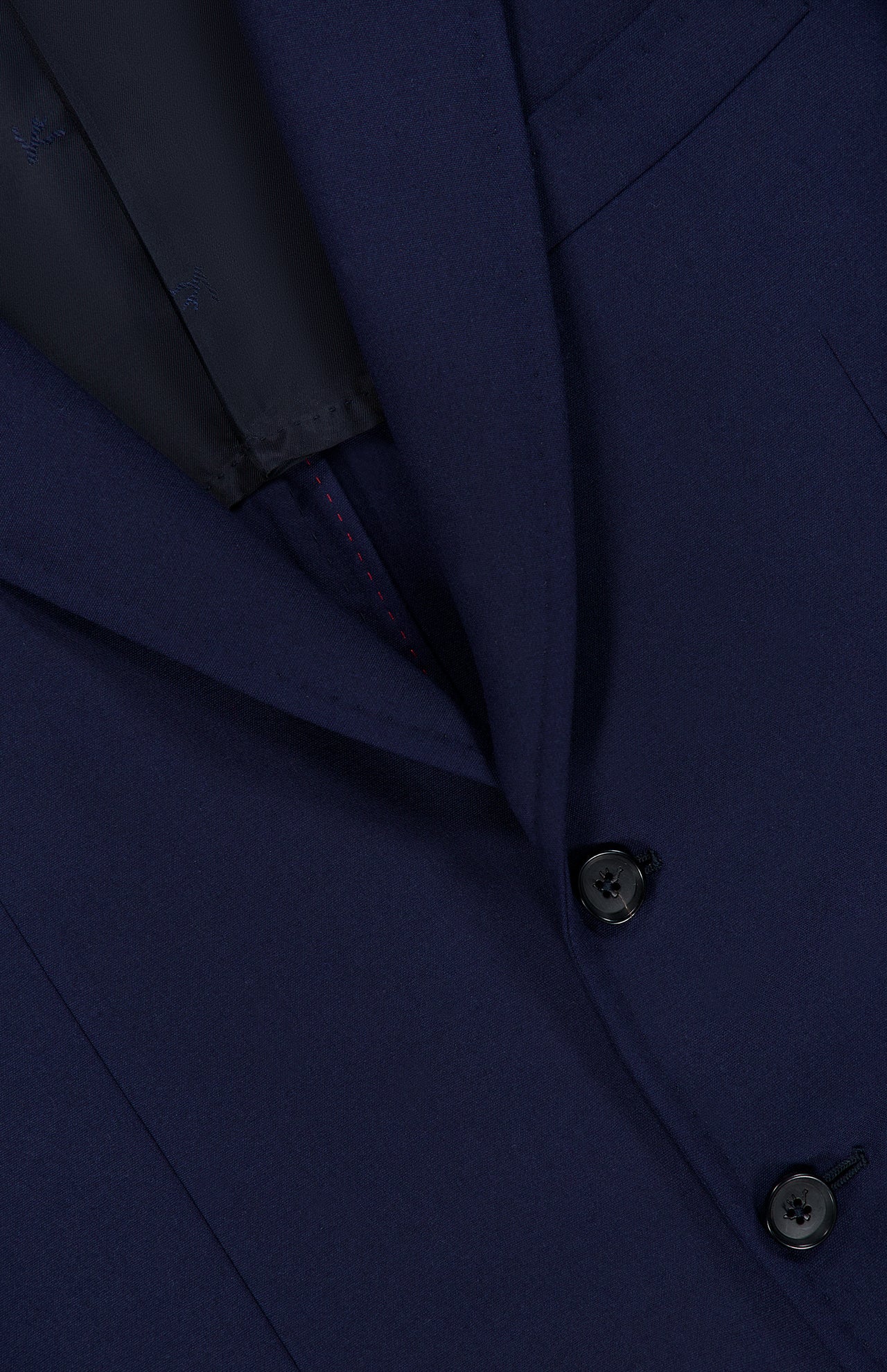 Close-up of the ISAIA Scuba Wool Comfort Suit Jacket, showcasing its dark blue hue with a focus on the lapel, two black buttons, and a glimpse of the pocket and inner lining.
