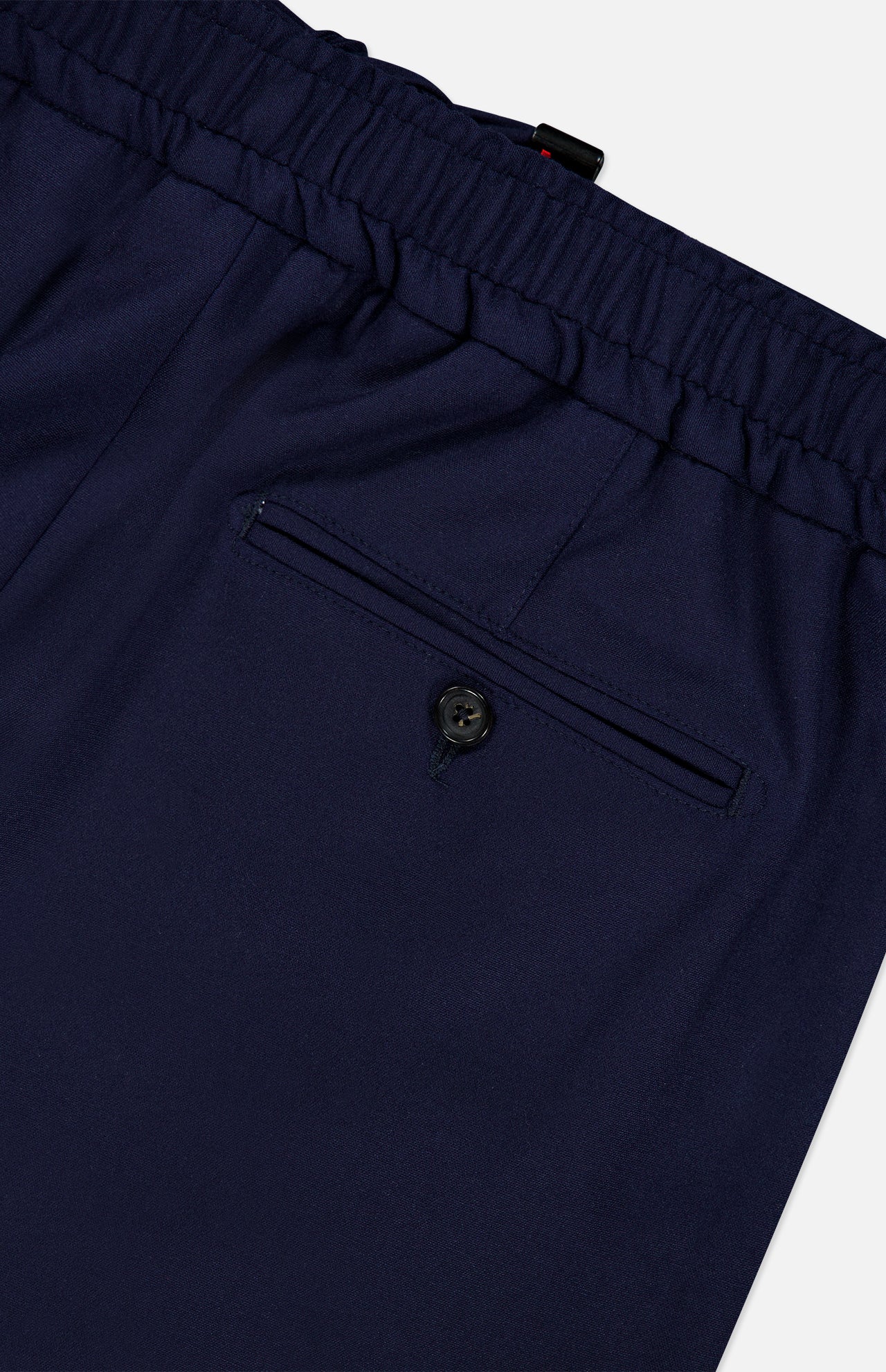 Here’s the revised sentence using your product data: Close-up of the back pocket on ISAIA’s Scuba Wool Comfort Suit Trouser in navy blue, featuring an elastic waistband. The pocket is finished with a button closure and a precisely stitched opening, reflecting refined Italian craftsmanship.