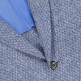Close-up of the ISAIA Soft Boucle Alpaca & Wool Sportcoat, crafted in Italy in a textured light blue fabric, featuring two dark buttons and a glimpse of its smooth, light blue inner lining.