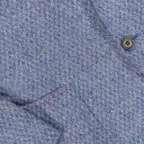 Close-up of the ISAIA Soft Boucle Alpaca & Wool Sportcoat in light blue, highlighting its textured fabric, two-button front, partial lapel, and pocket detail accented with subtle red stitching. This jacket blends comfort and elegance through its refined alpaca wool-blend construction.