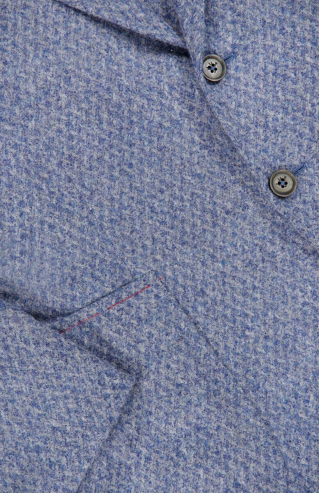 Close-up of the ISAIA Soft Boucle Alpaca & Wool Sportcoat in light blue, highlighting its textured fabric, two-button front, partial lapel, and pocket detail accented with subtle red stitching. This jacket blends comfort and elegance through its refined alpaca wool-blend construction.