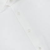 Close-up of the ISAIA Solid 2 Ply Dress Shirt, a white dress shirt with matching white buttons and a distinctive red label on the inside of the collar. This sophisticated Italian-made shirt exemplifies ISAIA’s renowned craftsmanship and timeless style, designed for those with discerning taste.