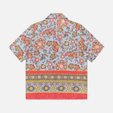The ISAIA Superlino Print Linen Floral Camp Shirt is a lightweight linen short-sleeve top with a red, yellow, and pink paisley print on light blue and decorative hem borders—an ideal vacation shirt.