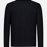 The ISAIA Two Button Knit Sportcoat in black is displayed from the back against a plain white background. Featuring a streamlined, unadorned design with a small collar and no visible buttons or embellishments on the reverse, this piece embodies the classic versatility of a casual sportcoat.