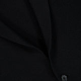 Close-up of black fabric from the ISAIA Two Button Knit Sportcoat, featuring a visible seam and a single black button. The texture of the knit fabric and detailed stitching are clearly shown, highlighting the garment’s quality craftsmanship.