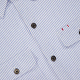 Close-up of the ISAIA Seersucker Effect Jersey Overshirt in light blue with black buttons and two chest pockets, one accented by subtle red stitching—the ideal piece for a nautical Italian summer look.
