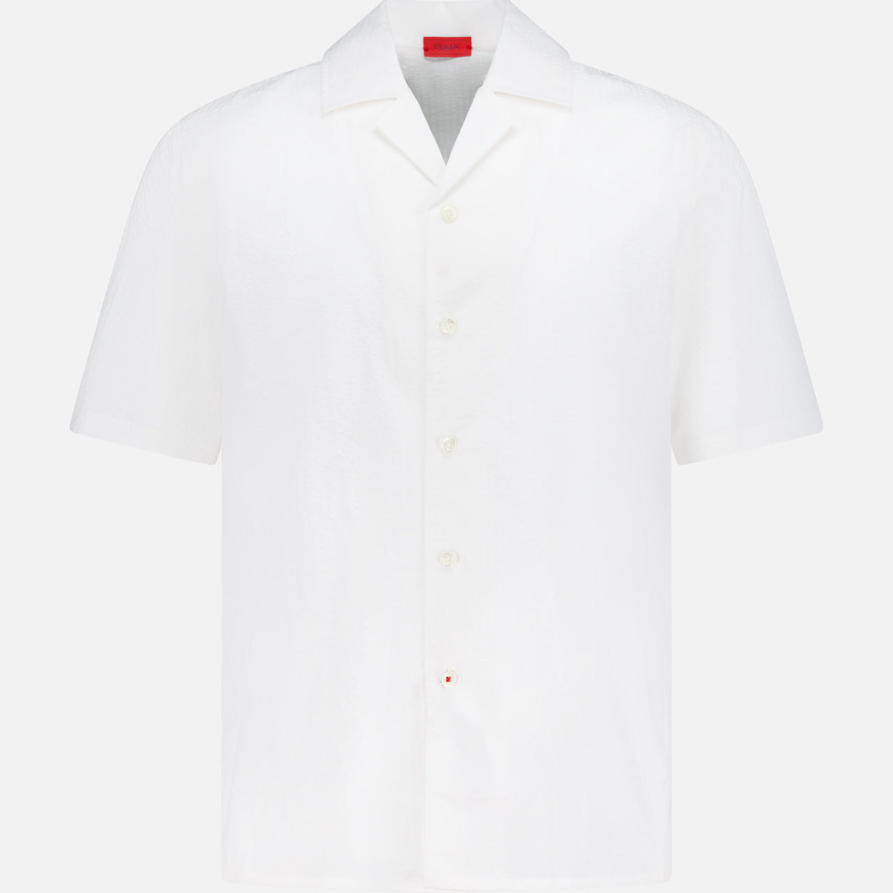 The ISAIA Seersucker Short Sleeve Camp Shirt is a men's white cotton button-up with short sleeves, a collar, and a small red tag by the hem, shown against a plain white background.
